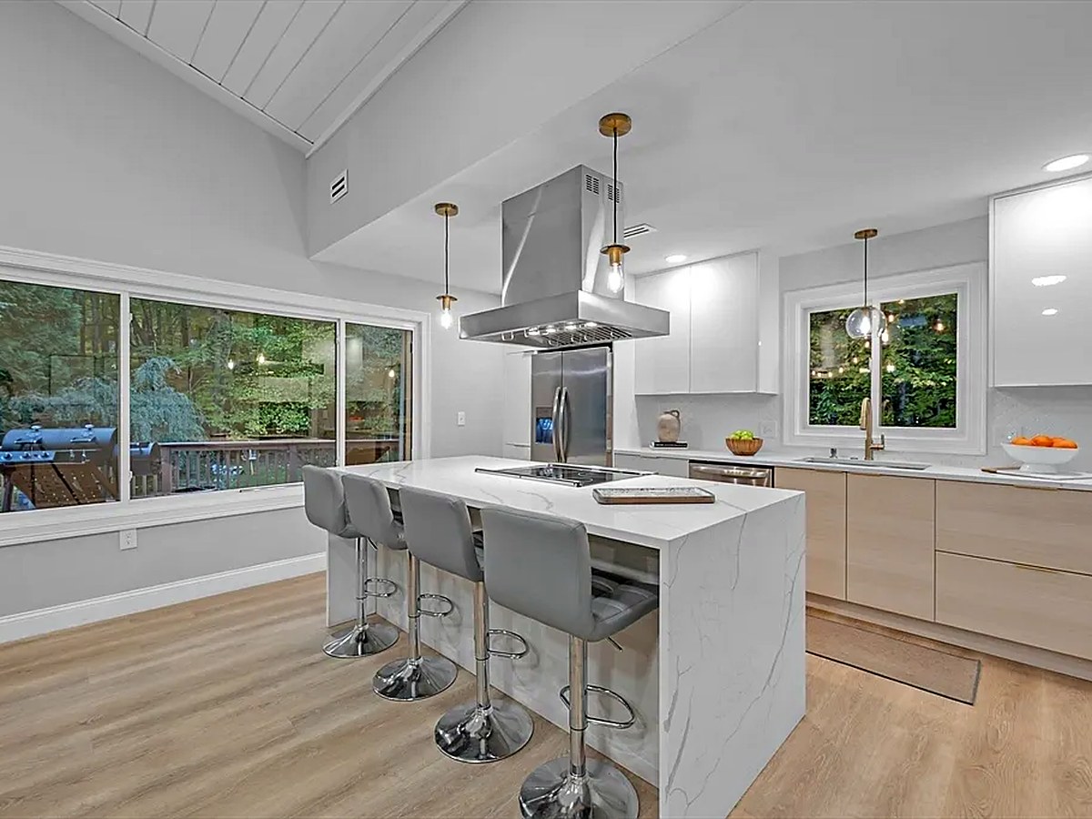 Kitchen with luxury vinyl plank flooring, quartz island and light oak cabinetry